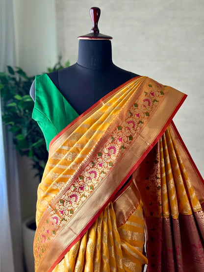 Orange yellow Katan Banarasi saree with silver zari and meenakari border