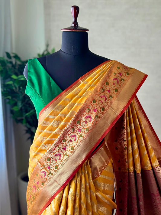 Orange yellow Katan Banarasi saree with silver zari and meenakari border